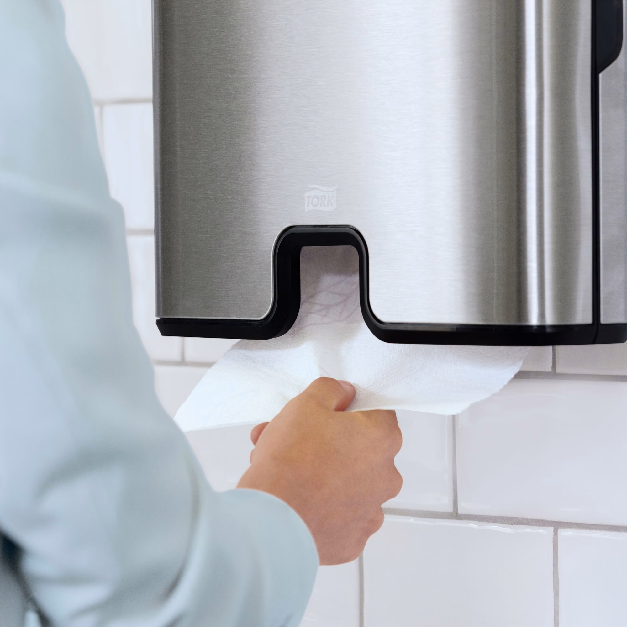 Tork Xpress® dozownik do ręczników Multifold, zbliżenie na pobieranie białego ręcznika papierowego dłonią