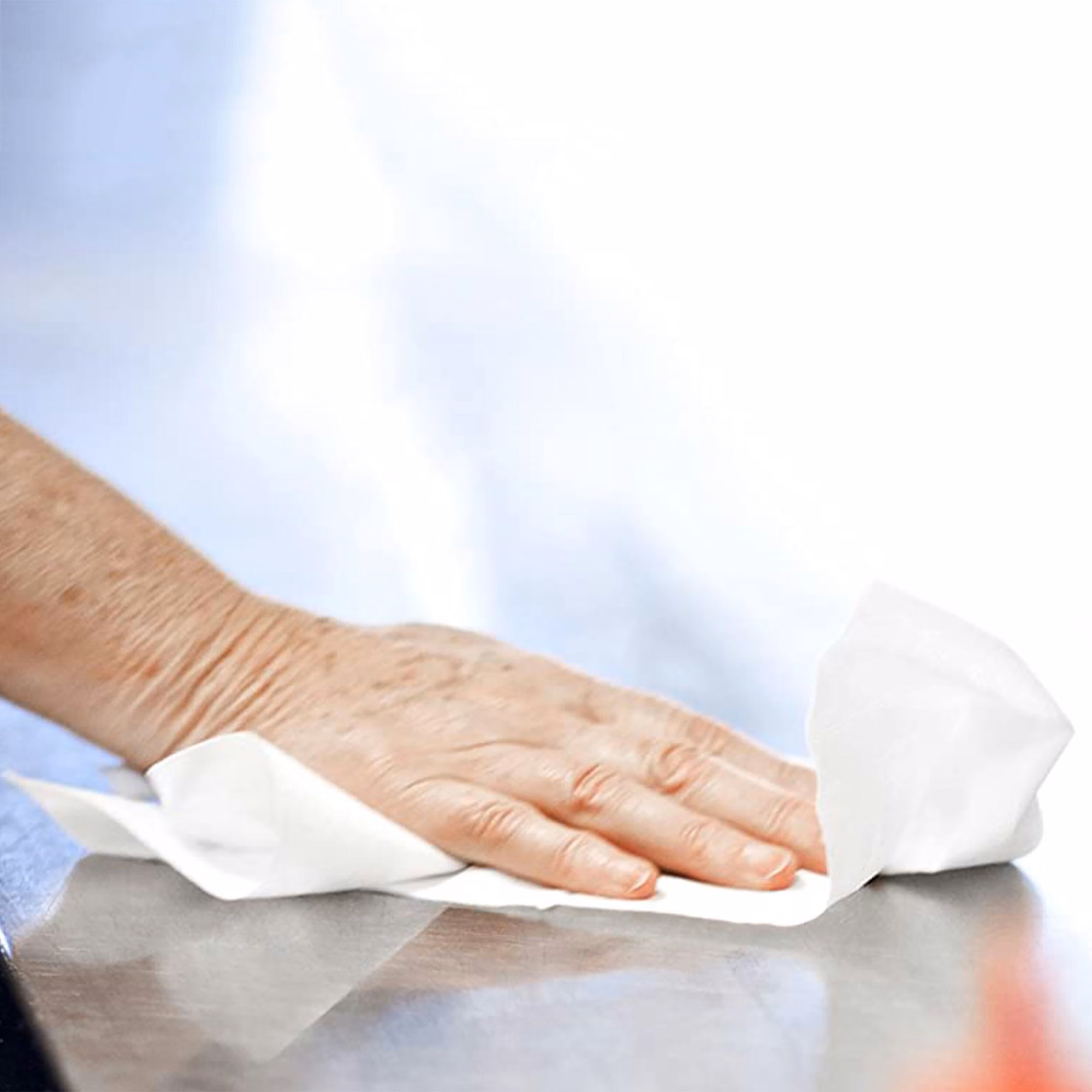 Tork czyściwo papierowe do średnich zabrudzeń, dłoń czyszcząca gładką powierzchnię białym arkuszem papieru